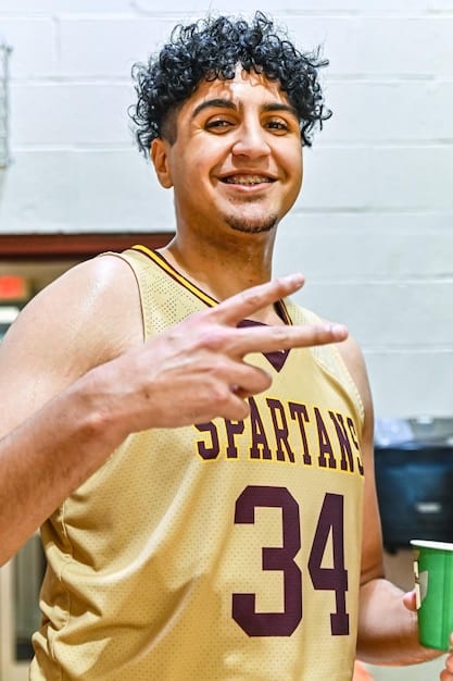 A close-up shot of a Kings League player celebrating a goal, with the sponsor's logo prominently displayed on the jersey and in the background. The player embodies youthful energy and excitement.