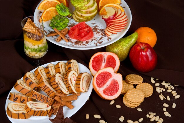 A brightly lit photograph showcasing a spread of various healthy and colorful snacks and drinks specifically designed for athletes. The spread includes sliced fruits, energy bars, hydration drinks, and small sandwiches. The presentation is clean and appealing.