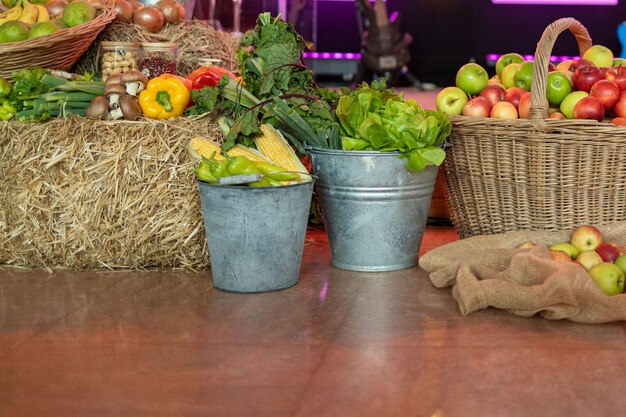 A wooden table laden with fresh, vibrant, and diverse produce from local farms. The produce includes colorful fruits, vegetables, and herbs. A farmer is visible in the background, tending to the crops.
