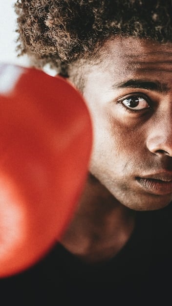 A close-up shot of Michael Brown participating in a reflex training drill. He's focused intensely on a series of rapidly flashing lights or moving targets designed to sharpen his reaction time. Modern training equipment surrounds him, illustrating the technological approach to his training regimen.