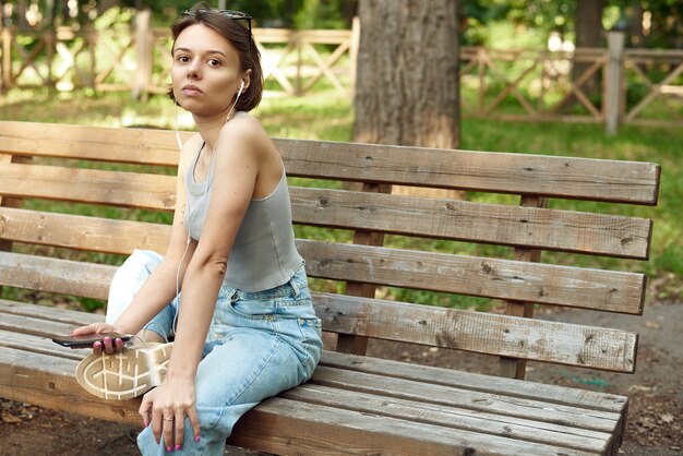 A close-up photo of Olivia Davis sitting on the bench with a concerned expression, her leg heavily bandaged. Medical staff is attending to her, showing support and care. The stadium background is slightly blurred, focusing attention on the seriousness of the moment and Davis's emotional state.