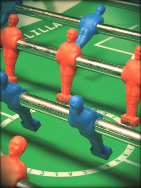 A dynamic close-up shot of players strategizing during a King's League USA match, with a coach pointing to a tactical board.